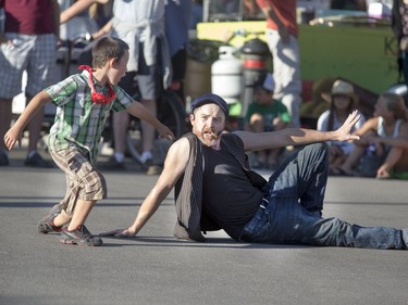 Street performer Russ poses for a picture with this boy who was break dancing to the music Russ was playing as the Australian performed to a large crowd at the at the Fringe Festival, August 2, 2016.