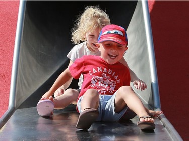 Alethia Bodrug and Tobiash Bodrug have fun on the Kinsmen Park slide in Saskatoon on Aug. 2, 2016.