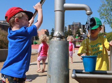 Kashton Hansen and Micah Tennent pump and fill up water at the water park at Kinsmen Park in Saskatoon on August 2, 2016.