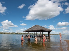 People swim around a gazebo that sits underwater at the beach in Manitou Beach, SK on Friday, August 5, 2016.