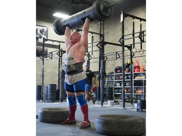 Competitors lift in the log bar event during the Saskatchewan amateur strongman provincial championship at Synergy Strength in Saskatoon, August 6, 2016.