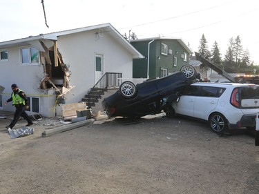 Police investigate a crash scene in an alleyway which involved a house at College Drive and Clarence Avenue, August 23, 2016.