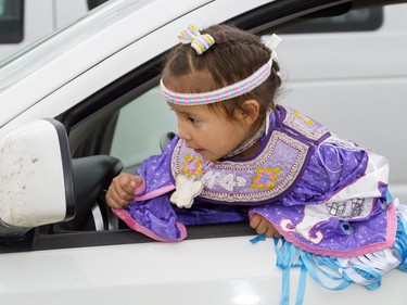 Three-year-old Kimiwan Bellegarde was checking out her outfit in the window of a minivan before participating in the Grand Entry for Wanuskewin Days Cultural Celebration and Powwow, August 23, 2016, in conjunction with the World Indigenous Business Forum at Wanuskewin Heritage Park.