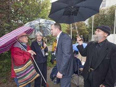 Leader of the Official Opposition Trent Wotherspoon (C) speaks with protestors about announced Sask. Party cuts to income assistance for the province's most vulnerable during a rally/protest at City Hall, August 26, 2016.