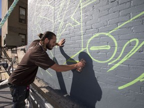 Artist Josh Jacobson had to quit his longstanding job and enlist the help of his brother and father-in-law in order to make a mural project on the side of the Drinkle Building in downtown Saskatoon possible. He posed with the work in progress, August 30, 2016.