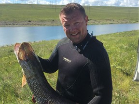 Spear fisherman Jonathan Ganshorn with the record-breaking 24-pound northern pike he caught on the South Saskatchewan River. (Saskatoon StarPhoenix