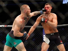 Conor McGregor (L) hits Nate Diaz with a left during their welterweight rematch at the UFC 202 event at T-Mobile Arena on August 20, 2016 in Las Vegas, Nevada.
