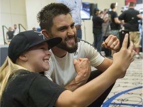 UFC fighter Carlos Condit (in white) meets fans at the Hyatt Regency hotel in Vancouver, BC on August 25, 2016