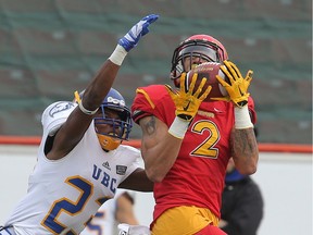 University of Calgary Dinos Rashaun Simonise (right) makes a catch as he is pressured by Dominique Termansen from the  the UBC Thunderbirds. UBC went on to win the Hardy Trophy in a 34-26 victory over the University of Calgary Dinos in Canada West university football action at McMahon Stadium in NW Calgary, Alta. Saturday November 14, 2015.