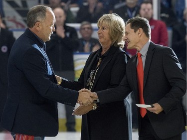 L-R: Retired NHL player Bryan Trottier shakes hands with Gordie Howe's daughter Cathy Howe and his son Murray Howe during a Thank You, Mr. Hockey Day in Saskatoon at SaskTel Centre, September 25, 2016. Howe's remains were interred at a statue of him outside of the arena earlier today.