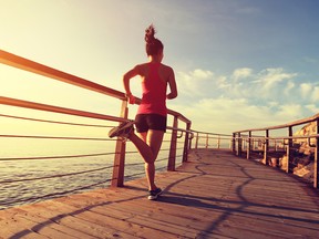 young fitness woman running on seaside wooden boardwalk