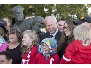 Mark Howe, son of Mr. Hockey Gordie shares a joke with members of his extended family following the internment of Gordie Howe's remains at the base of a statue of him during a memorial service outside Sasktel Centre in Saskatoon, Sunday, September 25, 2016.