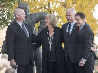 Marty Howe, son of Mr. Hockey Gordie Howe, left to right, his sister Cathy Howe, and brothers Mark, and Murray hug following the internment of Gordie Howe's remains at the base of a statue of him during a memorial service outside Sasktel Centre in Saskatoon,Sunday, September 25, 2016.
