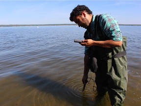 Ricardo Segovia of E-Tech International collects samples near where a Husky Energy Inc. pipeline spilled up to 250,000 litres of oil on July 20.