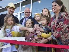 Twelve-year-old Micah Anderson squeezed in left of MLA Lisa Lambert and surrounded by his parents Doug and Caroline and four sisters with Rick Prinzen with Canadian Blood Services cut the ribbon to open the new office on Emerson Avenue, September 21, 2016. Micah was a recipient of blood after battling cancer.