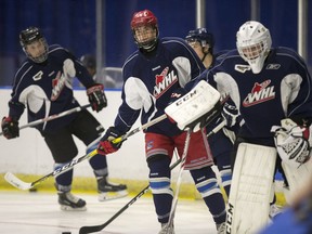 Fifteen-year-old Blades rookie Kirby Dach (centre) will remain with the team through training camp.