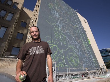 Artist Josh Jacobson had to quit his longstanding job and enlist the help of his brother and father-in-law in order to make a mural project on the side of the Drinkle Building in downtown Saskatoon possible. He posed with the work in progress, August 30, 2016.