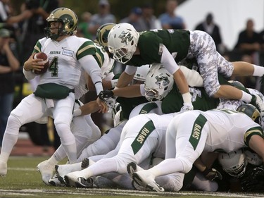 U of S Huskeis' Bowan Lewis tries to climb the pack to get at Regina Rams quarterback Noah Picton in CIS University football action at Griffiths Stadium in Saskatoon, September 2, 2016.
