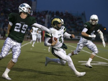 Regina Rams' Noah Picton runs for some yards against U of S Huskies' Spencer Krieger and Ben Whiting in CIS University football action at Griffiths Stadium in Saskatoon, September 2, 2016.