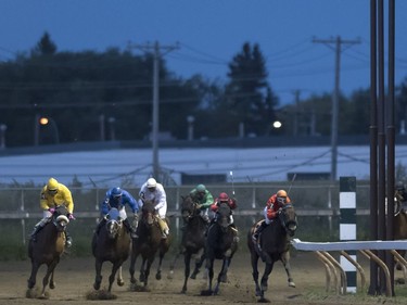 Jockeys race horses on the final night of racing for the season at Marquis Downs in Saskatoon, September 3, 2016.