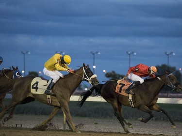 Jockeys race horses on the final night of racing for the season at Marquis Downs in Saskatoon, September 3, 2016.