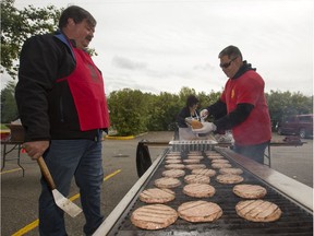 People lined up in Victoria Park for burgers and and drink, along with live music and balloons, Monday, September 05, 2016, during the Saskatoon & District Labour Council's Labour Day BBQ in the park. Kim Wehner, local 7689, left, and Doug McLaughlin, local 80 IAFF, cook some burgers.