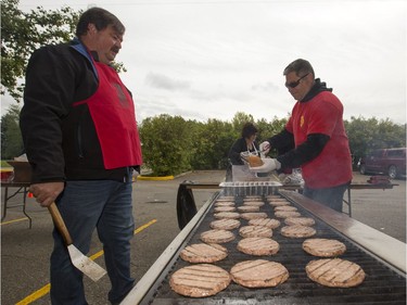 People lined up in Victoria Park for burgers and drink, along with live music and balloons, September 5, 2016, during the Saskatoon & District Labour Council's Labour Day BBQ in the park. Kim Wehner, local 7689 (L) and Doug McLaughlin, local 80 IAFF, cook some burgers.