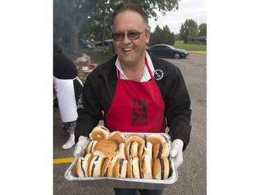 People lined up in Victoria Park for burgers and drink, along with live music and balloons, September 5, 2016, during the Saskatoon & District Labour Council's Labour Day BBQ in the park. Jim Yakubowski of the Amalgamated Transit Union 615 gets some burgers ready.