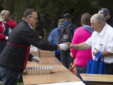 People lined up in Victoria Park for burgers and drink, along with live music and balloons, September 5, 2016, during the Saskatoon & District Labour Council's Labour Day BBQ in the park. Jim Yakubowski of the Amalgamated Transit Union 615 (L) hands out some burgers.