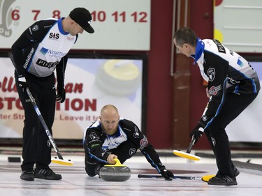 Skip Brad Jacobs (C) throws a rock with sweepers Ryan Harnden and E.J. Harnden in action during the championship final in the World Curling Tour's College Clean Restoration Curling Classic at the Nutana Curling Club, September 26, 2016.