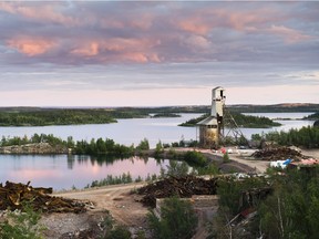 The abandoned Gunnar uranium mine, with the flooded mine pit on the left and decaying headframe on the right, as it appeared in 2011. The headframe has since been demolished.