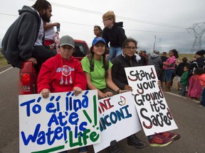 Youths hold signs in English and the Najavo language before the start of a march to a burial ground sacred site that was disturbed by bulldozers building the Dakota Access Pipeline (DAPL), near the encampment where hundreds of people have gathered to join the Standing Rock Sioux Tribe's protest of the oil pipeline that is slated to cross the Missouri River nearby, September 4, 2016 near Cannon Ball, North Dakota. Protestors were attacked by dogs and sprayed with an eye and respiratory irritant yesterday when they arrived at the site to protest after learning of the bulldozing work. /