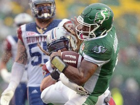 Roughriders quarterback Darian Durant, right, absorbs a hit from the Alouettes' Bear Woods on Saturday at Mosaic Stadium.