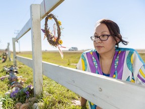 Janine Windolph, president of the Regina Indian Industrial School commemorative association, at a fence that marks the RIIS cemetery in Regina.