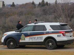 Members of the Saskatoon Police Service stand beside a police vehicle in the area Seminary Crescent and North Road of the University of Saskatchewan campus on Saturday morning as they tried to locate an aggressive coyote.  (Morgan Modjeski/The Saskatoon StarPhoenix)