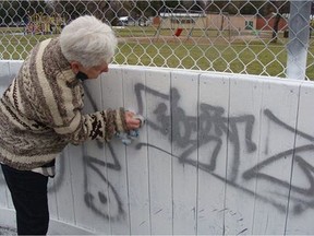 President of the Montgomery Place Community Association Barb Biddle, attempts to remove graffiti from the Montgomery Place Rink on Monday. She thinks the graffiti appeared over the weekend, calling it both frustrating and disappointing, as the rink was recently rejuvenated with new paint and improvements, some of the work which will now have to be redone.
