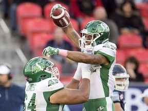 The Saskatchewan Roughriders' Joe Craig, right, celebrates a 71-yard punt-return touchdown with Andrew Jones.