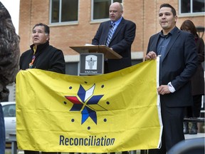 Neal Kewistep, right, and his father Gilbert hold a flag of reconciliation at St. Paul's Hospital. (Gord Waldner/Saskatoon StarPhoenix.)