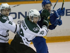 Saskatchewan Huskies #28 John Lawrence bounces #17 Cameron Blair of the University of B.C. Thunderbirds in the defensive zone in CIS action in Saskatoon, October 7, 2016.