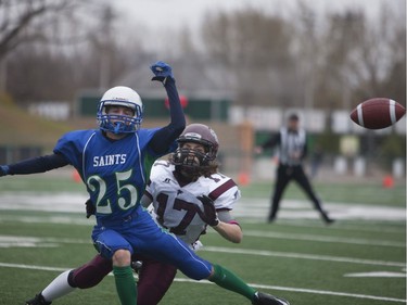 Bishop J. Mahoney Saints #25 Jason Dittmer and Marion Graham Falcons #17 Ian Finstad clash after both players attempt to catch the ball during the Saskatoon 3A high school football finals at SMF Field in Saskatoon, October 29, 2016.