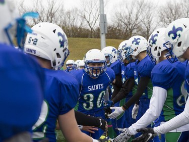 Bishop J. Mahoney Saints #30 Andrew Zdunich runs past his teammates before the coin toss during the Saskatoon 3A high school football finals at SMF Field in Saskatoon, October 29, 2016.