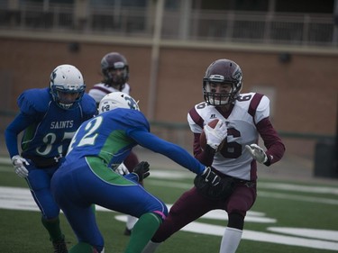 Marion Graham Falcons #6 Alex Dewar runs past a Bishop J. Mahoney Saints defenceman during the Saskatoon 3A high school football finals at SMF Field in Saskatoon, October 29, 2016.