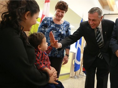Education minister Don Morgan high fives Jocelynn Arcand's son who attends the newest USSU childcare centre at the McEown location in Saskatoon on October 17, 2016.