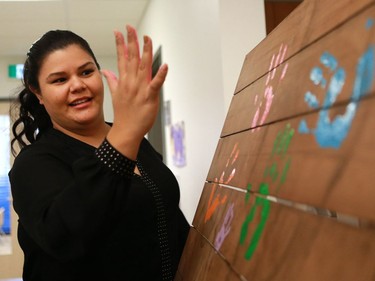 University of Saskatchewan student Jocelynn Arcand stamps her handprint on a board during the official opening of the newest USSU childcare centre at the McEown location in Saskatoon on October 17, 2016.