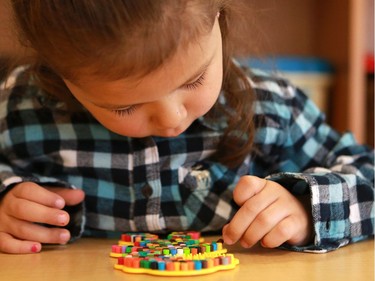 Raelle Hegland works on a tedious craft in the Firefly room during the official opening of the newest USSU childcare centre at the McEown location in Saskatoon on October 17, 2016.