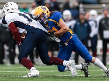 Saskatoon Hilltops' Adam Ewanchyna tackles Regina Thunder's Robbie Lowes during the first half of the PFC junior football semifinal at SMF Field in Gordie Howe Park in Saskatoon on October 23, 2016.