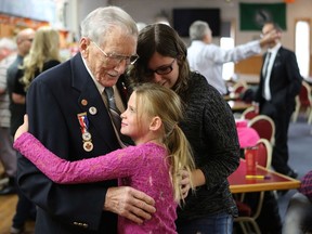 Nevaeh and Hailey Moore hug their 92-years-old great grandfather Lorne Figley during a celebration of him breaking the world record by becoming oldest plumber according to the Guinness Book of World Records at Nutana Legion in Saskatoon on October 23, 2016.