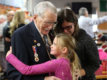 Nevaeh and Hailey Moore hug their 92-year-old great grandfather Lorne Figley during a celebration of him breaking the world record by becoming the oldest plumber according to the Guinness Book of World Records at Nutana Legion in Saskatoon on October 23, 2016.