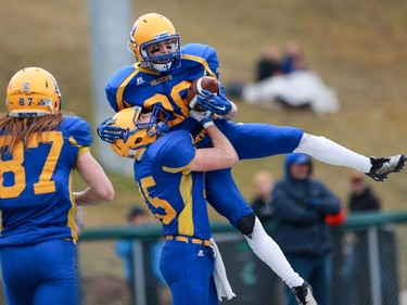 Saskatoon Hilltops' Ryan Turple picks up Rylan Kleiter after he scored a touchdown during the Prairie Football Conference championship game against the Calgary Colts at SMF field in Saskatoon on October 30, 2016.