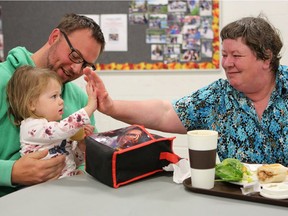 Darren Ardell and his daughter Levi, volunteers from Connect Church, share a table with Joan Dowd who is enjoying a Thanksgiving lunch at the Lighthouse in Saskatoon on Oct. 9, 2016.